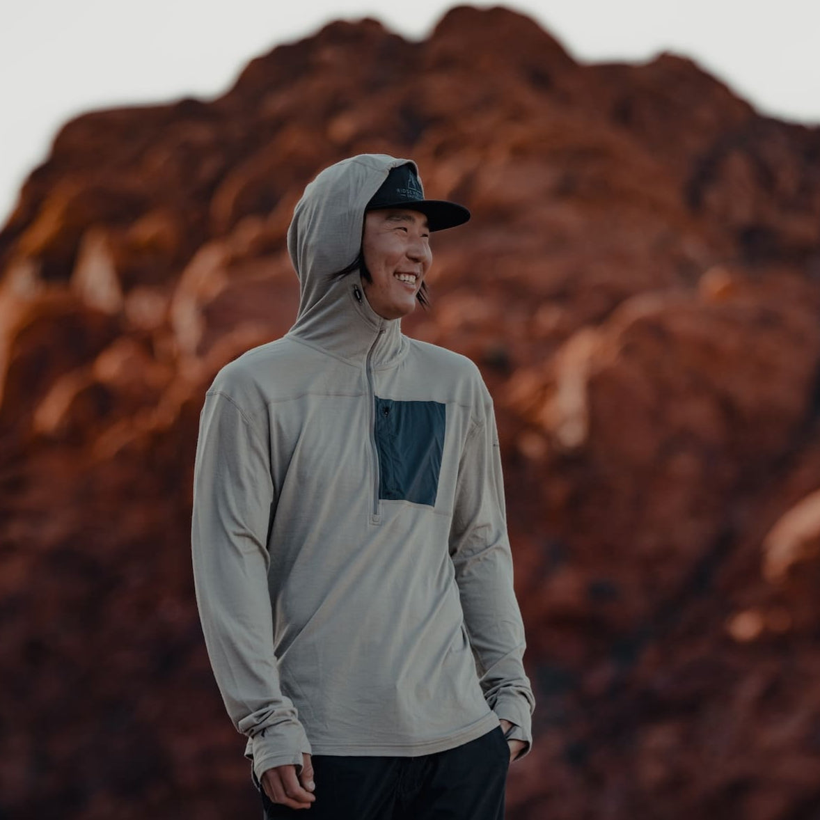 a man laughs wearing a Ridge Solstice Pro Sun hoodie in the desert