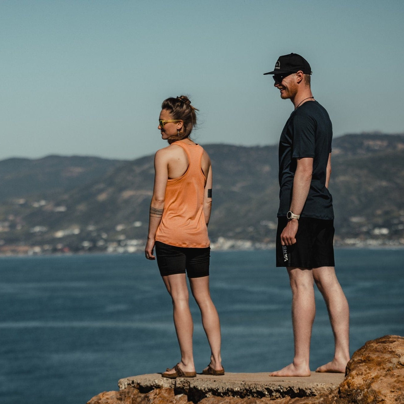 a woman wearing the Frankie Tank stands with her friend overlooking the beach