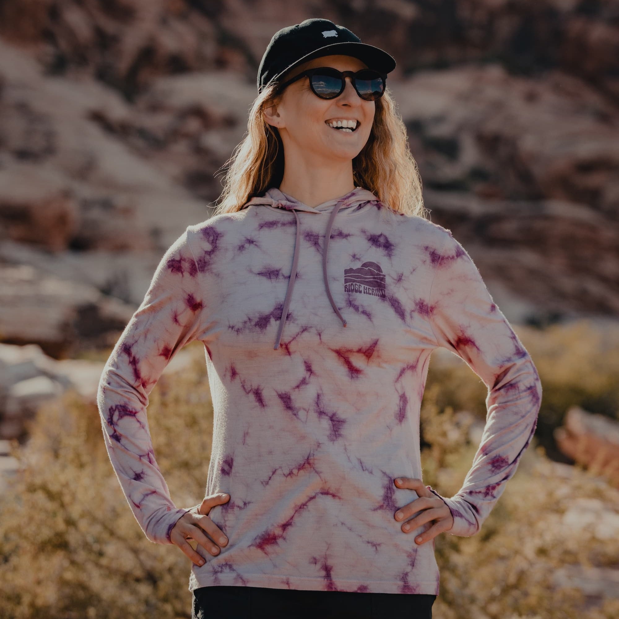 a woman wearing a tie-dye Solstice Sun Hoodie