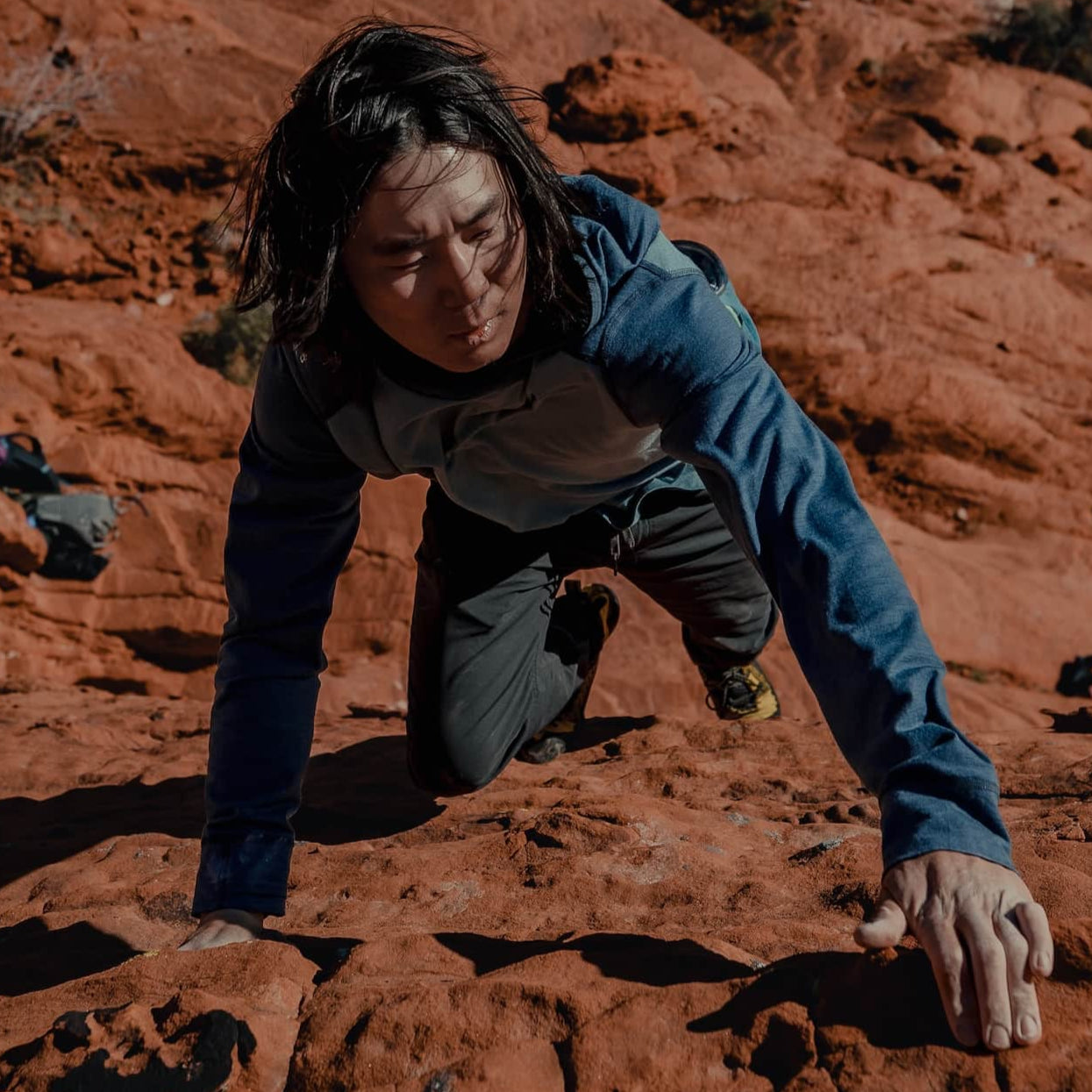 a man bouldering in a Pursuit Hoodie