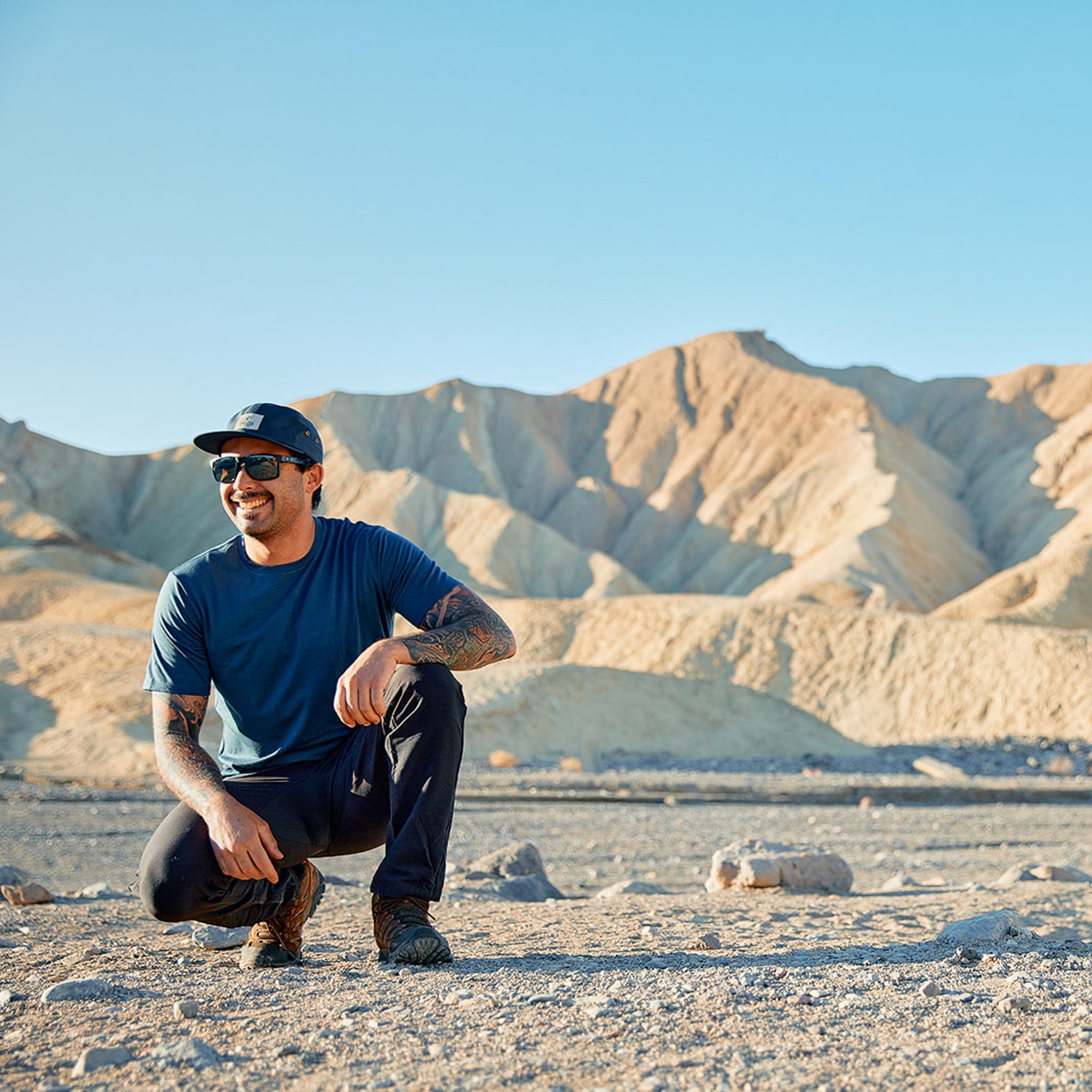 A man on a hike in Death Valley wearing the Natural Merino Tencel Tee